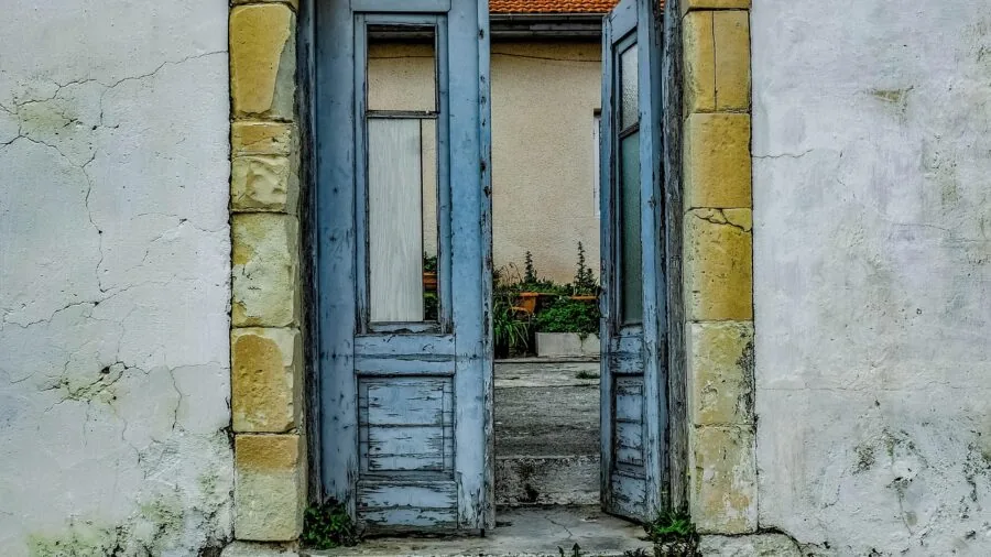 Weathered wooden door with water droplets after rain, showing outdoor exposure and durability in natural light