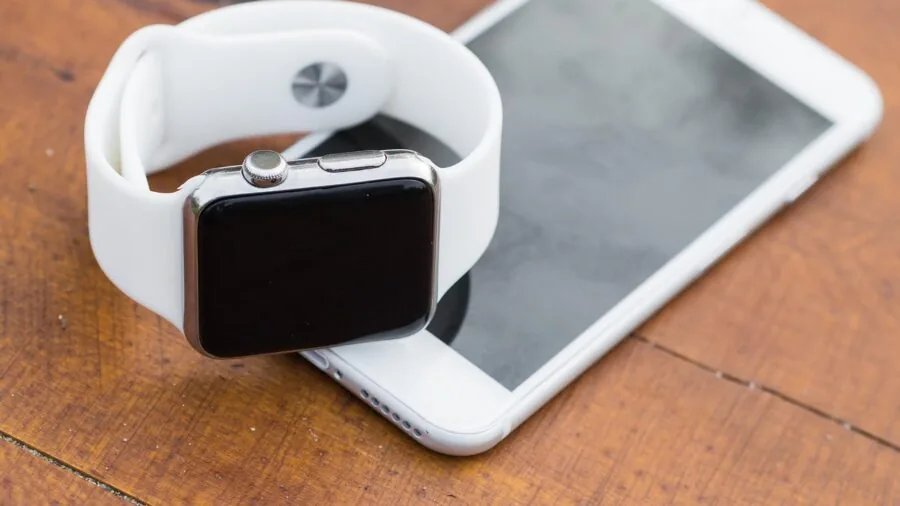 Woman comparing smartphone and smartwatch devices to check compatibility and features
