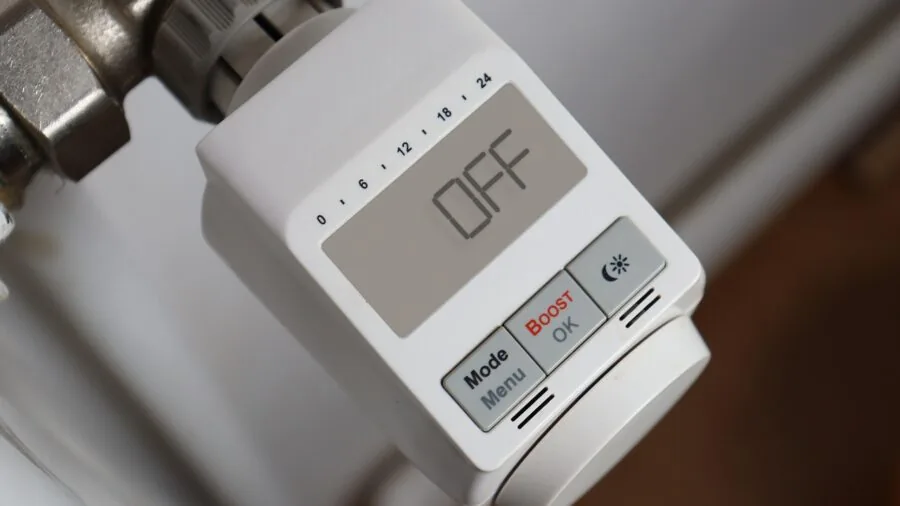 Woman using voice command to control smart home temperature from living room couch