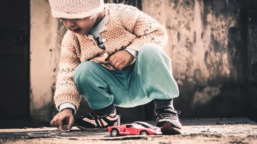 Young child enjoying handheld gaming in natural daylight, focusing on screen visibility and comfortable play posture