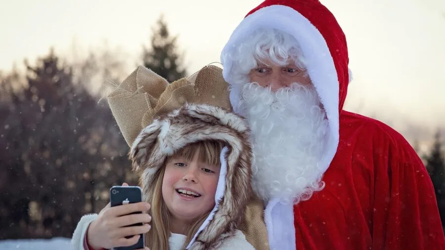 Young child holding camera outdoors, capturing nature scene in natural daylight