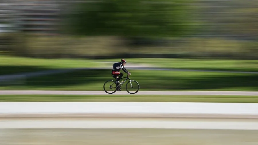 Young child holding camera while running outdoors, capturing motion and movement in natural daylight