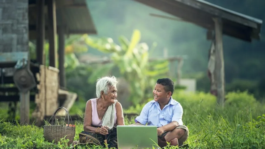 Young child outdoors learning to operate remote control device with adult supervision in open field