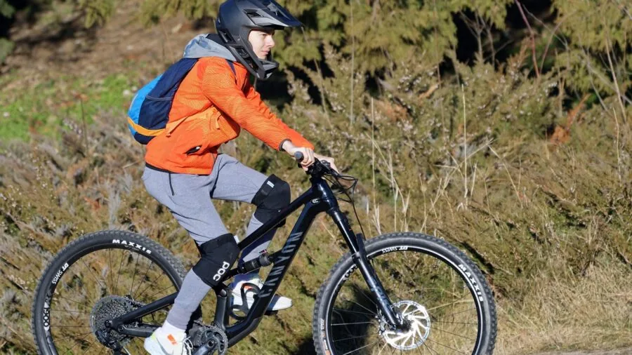 Young child riding bicycle outdoors with action camera mounted on helmet