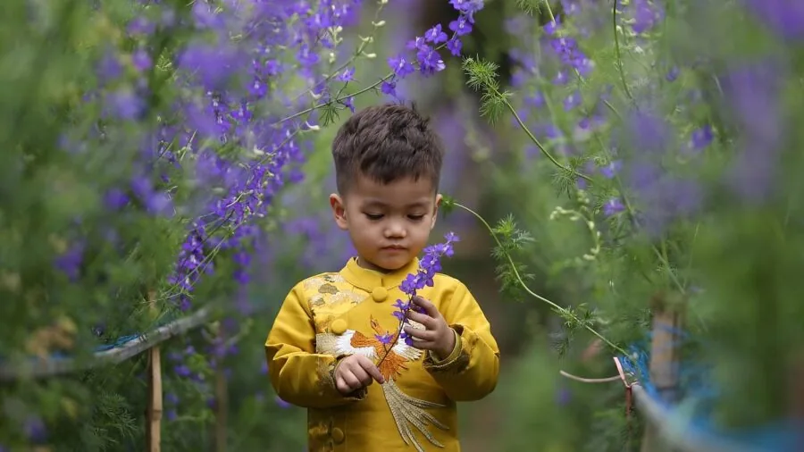 Young child running through an open grassy field on a sunny day, demonstrating outdoor activity where GPS tracking is needed
