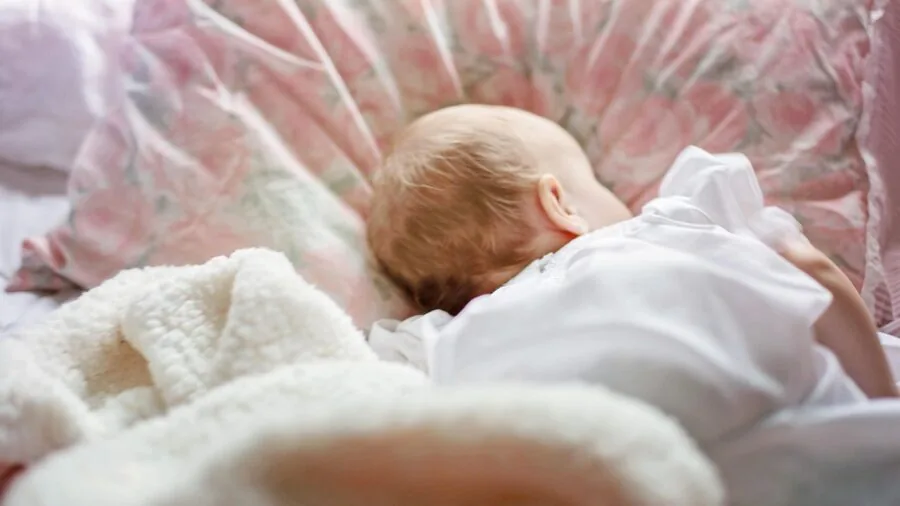 Young child sleeping peacefully in bed at night, illustrating the importance of uninterrupted rest and device reliability for toddlers.