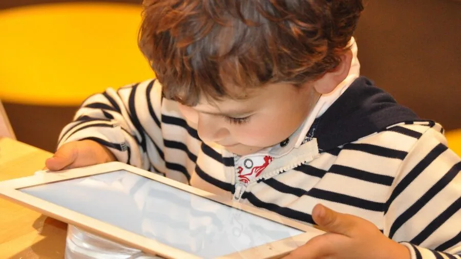 Young child using tablet device for educational content at home