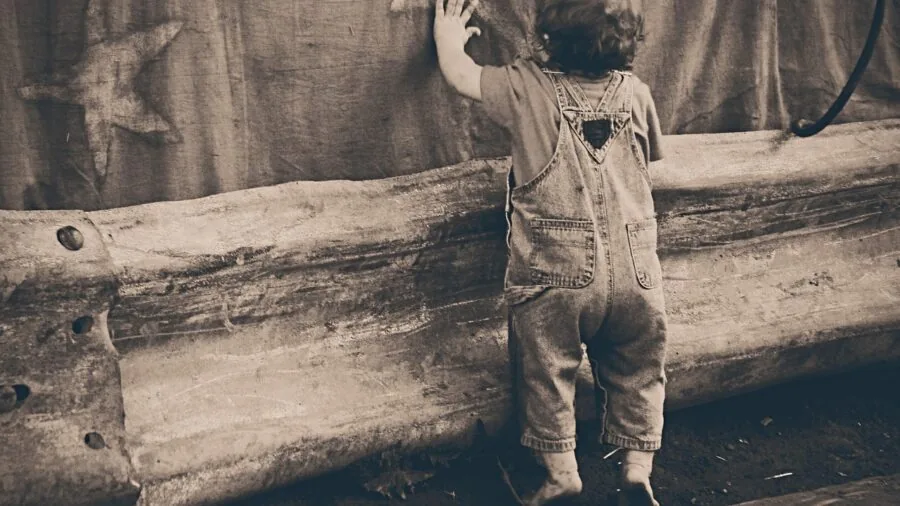 Young child wearing a smartwatch while playing outside in natural daylight, focused on device on wrist
